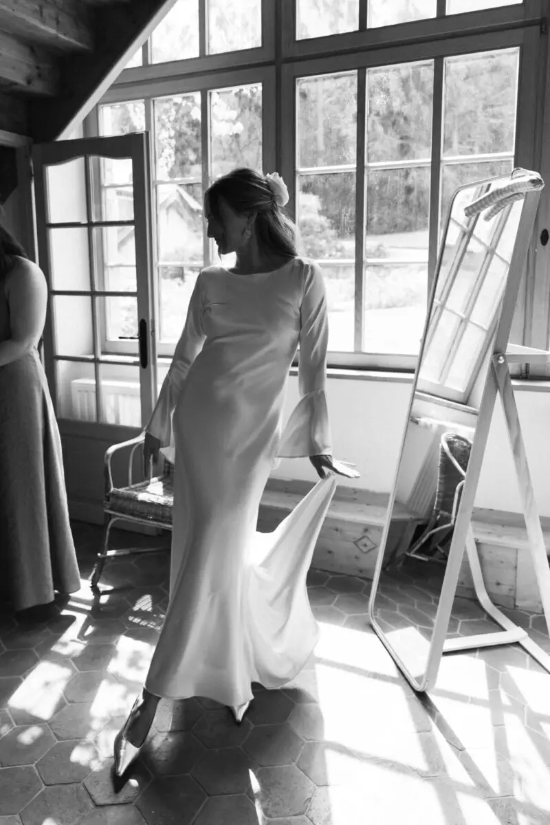 Mariée en robe satinée dans une pièce baignée de lumière