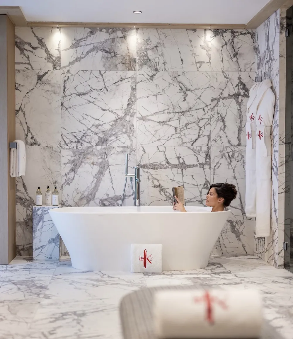 Photo shoot at the K2 Palace in Courchevel, woman reading in a marble bathtub