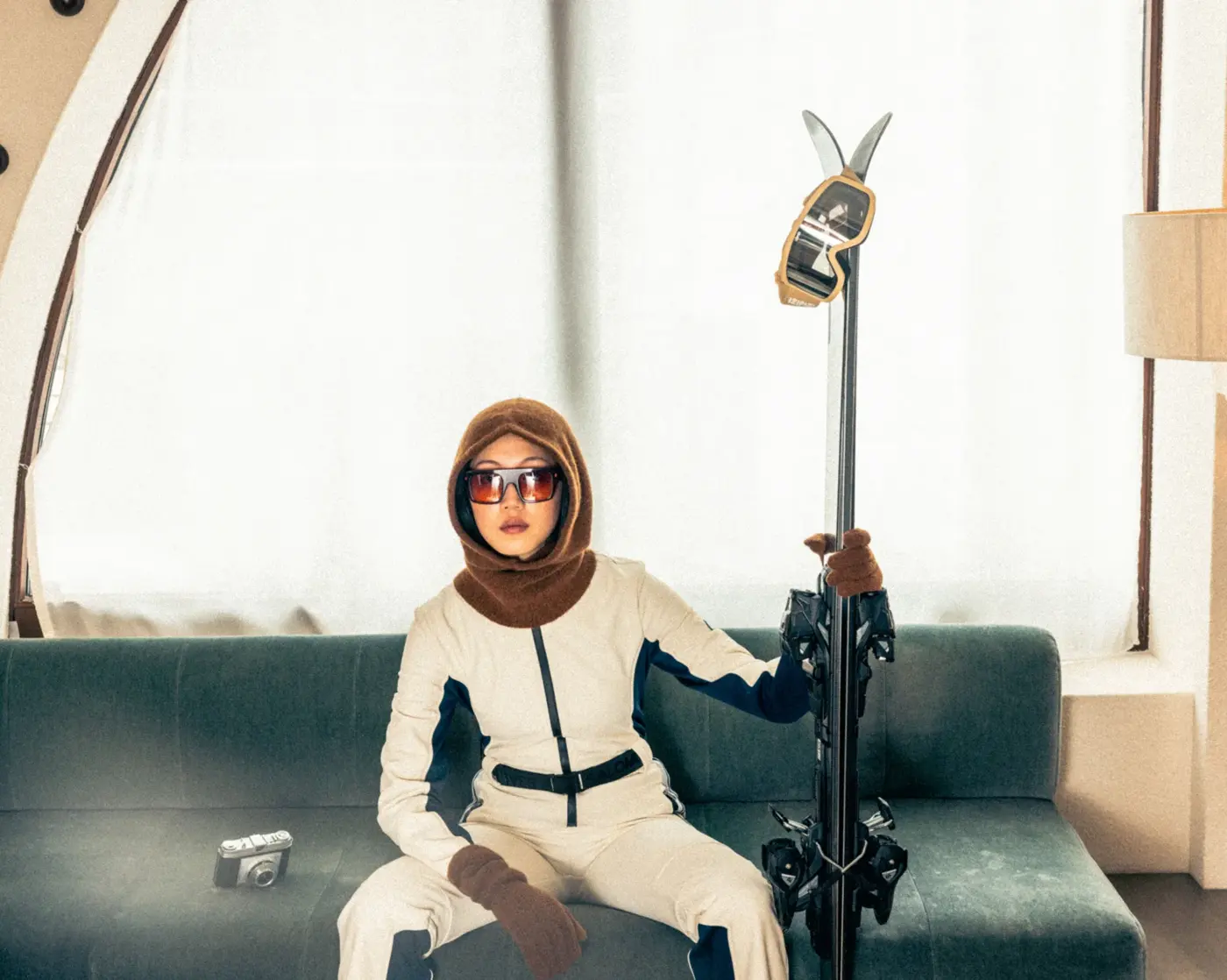 Skier on a sofa with her skis