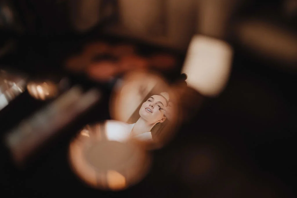 Coaching maquillage : reflet d'une femme qui se maquille dans un miroir